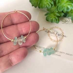 May include: Gold hoop earrings with three light blue sea glass beads.