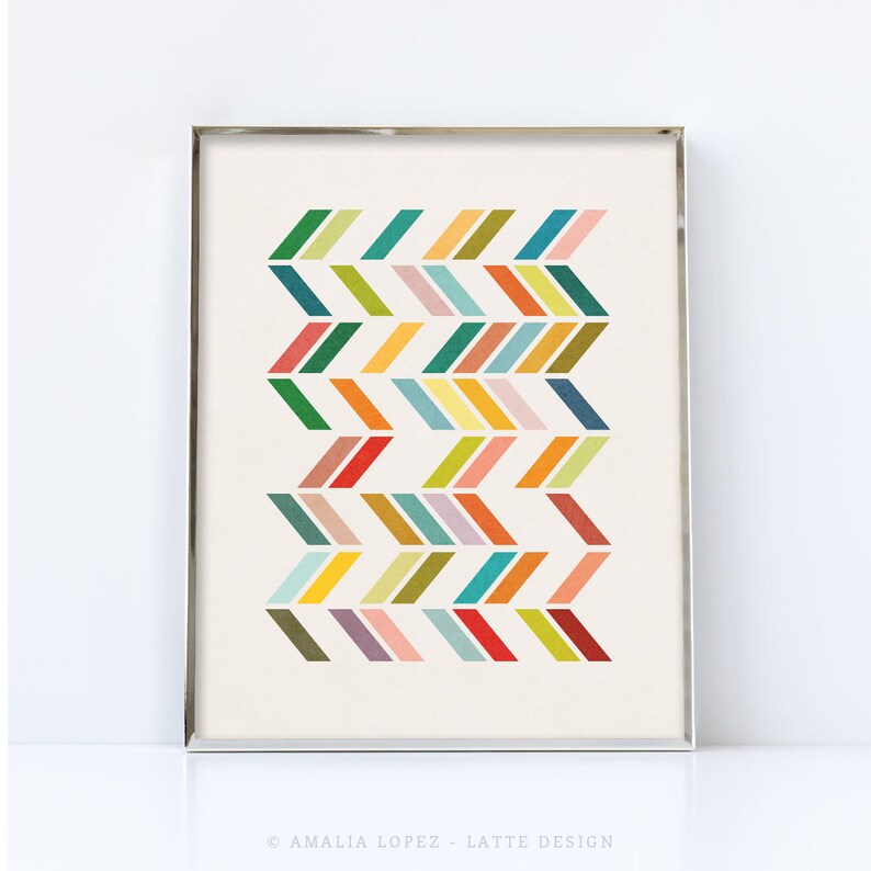 May include: A digital print with a geometric pattern of colorful chevron shapes in shades of green, yellow, orange, red, blue, and purple. The print is framed in a silver frame.
