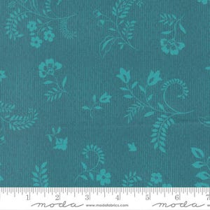 May include: Teal fabric with a vertical striped texture and a repeating pattern of stylized floral and leaf designs in a lighter teal color. The fabric is marked with a ruler along the bottom edge.
