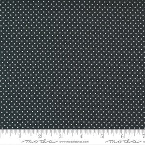 May include: Black fabric with a white polka dot pattern. The fabric is shown with a ruler for scale.