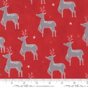 May include: Red fabric featuring a repeating pattern of grey reindeer with white spots and antlers. White stars and floral accents are scattered across the fabric. The fabric has a Moda label at the bottom.