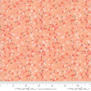 May include: Peach-colored fabric with a repeating pattern of white and coral-red floral designs. The fabric has a ruler along the bottom edge with the word "moda" printed on it.