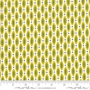 May include: White fabric with a repeating pattern of green and black ovals. The fabric is marked with a ruler in inches and the word "moda" appears twice.