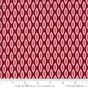 May include: Red fabric with a repeating pattern of pink and gray ovals. The fabric is marked with a ruler in inches and the text "moda" appears twice.