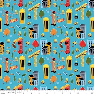 May include: A blue fabric with a repeating pattern of construction vehicles, buildings, and trees. The pattern includes yellow construction trucks, red cranes, and yellow and gray buildings. The text "Junior Crew" appears in the pattern.