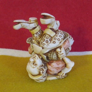 May include: A ceramic figurine of a clown standing on their head with their legs in the air. The clown is wearing a colorful outfit with polka dots and a hat. The figurine is painted in shades of brown, white, and pink.