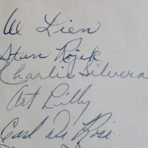 May include: A handwritten list of names, including "Al Lien", "Stan Rojik", "Charlie Silvera", "Art Lilly", and "Carl De Rose".