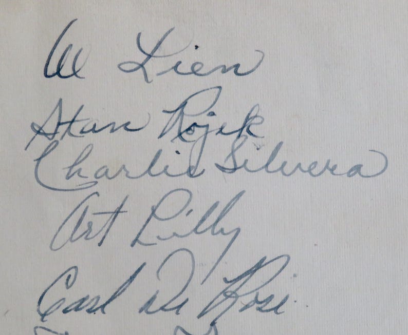 May include: A handwritten list of names, including "Al Lien", "Stan Rojik", "Charlie Silvera", "Art Lilly", and "Carl De Rose".