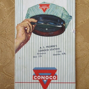 May include: A vintage Conoco gas station map for Marion, Arkansas. The map features a Conoco logo with a red and blue triangle and the text "Conoco". The map also includes the text "The Land of Opportunity" and "A.L. Pilgrim's Conoco Station".