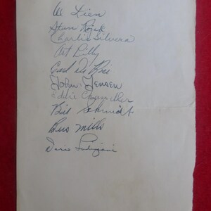 May include: A white sheet of paper with handwritten signatures of various people, including Lien, Stan Dojek, Charlie Silvera, Art Lilly, Carl Mihri, Job Jensen, Eddie Chngay ther, Beit Shund, Bus mills, and Dario Falijani.