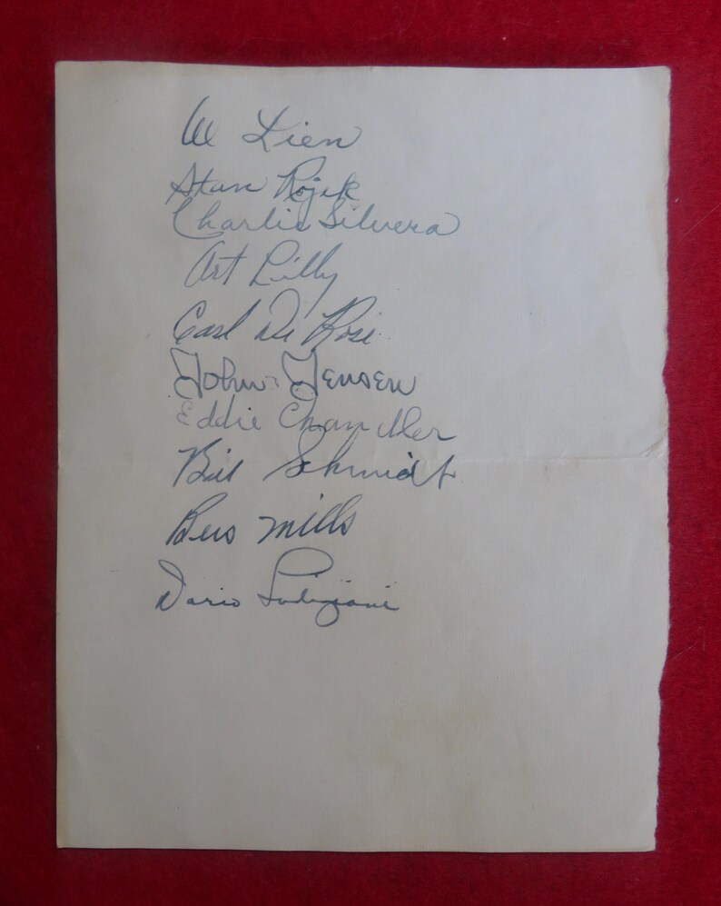 May include: A white sheet of paper with handwritten signatures of various people, including Lien, Stan Dojek, Charlie Silvera, Art Lilly, Carl Mihri, Job Jensen, Eddie Chngay ther, Beit Shund, Bus mills, and Dario Falijani.