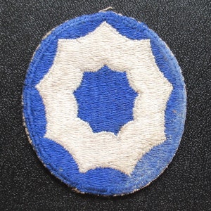 May include: A blue and white embroidered patch with a white eight-pointed star in the center. The star is surrounded by a blue circle with a white border.