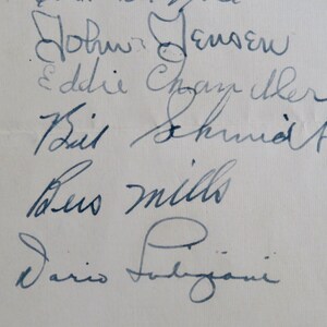 May include: A close-up of five handwritten signatures on a white piece of paper. The signatures are: John Jensen, Eddie Chazelle, Bill Schmidt, Leo Mills, and Dario Faligiani.