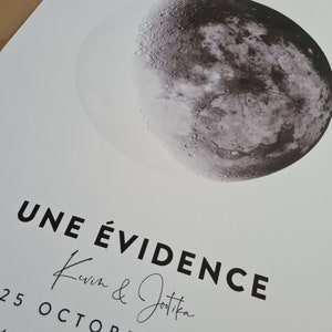 May include: A black and white image of a crescent moon with the text "UNE &Eacute;VIDENCE Kevin & Jotika 25 OCTOBRE 2020 45'37.933', | 0&deg;" printed below.
