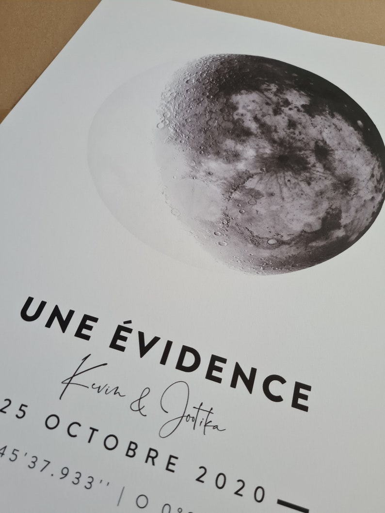 May include: A black and white image of a crescent moon with the text "UNE &Eacute;VIDENCE Kevin & Jotika 25 OCTOBRE 2020 45'37.933', | 0&deg;" printed below.