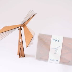 Op de afbeelding: Een meerlaags, geometrisch houten beeldhouwwerk met een witte achtergrond. Het beeldhouwwerk is getiteld "CHIL" en is gemaakt door BINDESIGN.
