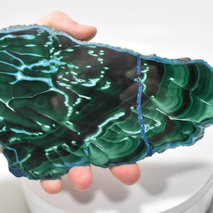 May include: A large, green and blue malachite slab with a swirling, banded pattern. The slab is polished and has a smooth surface.