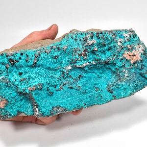 May include: A large, rough, teal blue and grey rock with a copper-coloured mineral deposit. The rock has a textured surface and is covered in small, round, blue crystals.