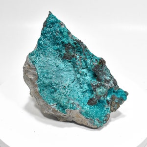 May include: A large, rough, grey rock with a teal blue mineral deposit covering most of the surface.