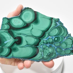 May include: A large, green and blue malachite slab with a swirling, concentric pattern. The slab is polished and has a smooth surface.