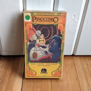 May include: A VHS tape of the film Pinocchio from the Fairytale Theatre series. The cover features a cartoon image of Pinocchio with Geppetto and Jiminy Cricket. The actors listed are James Coburn, Carl Reiner, and Paul Reubens.