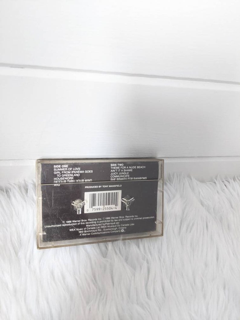 May include: A black cassette tape with the title "Summer of Love" and the artist "Wig" printed on the front. The back of the tape lists the songs on each side, including "Theme for a Nude Beach" and "Ain't It a Shame".