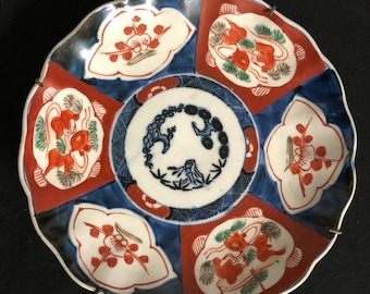 Plato de cerámica japonesa Imari, principios del siglo XX, Arita/Meiji, con decoración floral azul y roja.