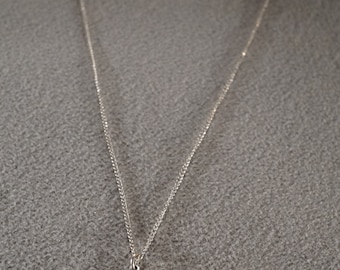 May include: A silver chain necklace with a silver cross pendant. The cross has a detailed design.