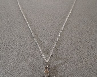 May include: A silver chain necklace with a silver cross pendant. The cross has a detailed design with lines radiating from the center.