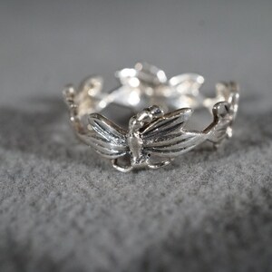 May include: Silver ring with a delicate design of multiple butterflies.