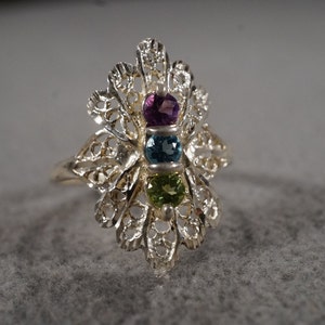 vintage sterling silver statement ring with filigree designs surrounding three round stones in amethyst, blue topaz and peridot, size 7  M2