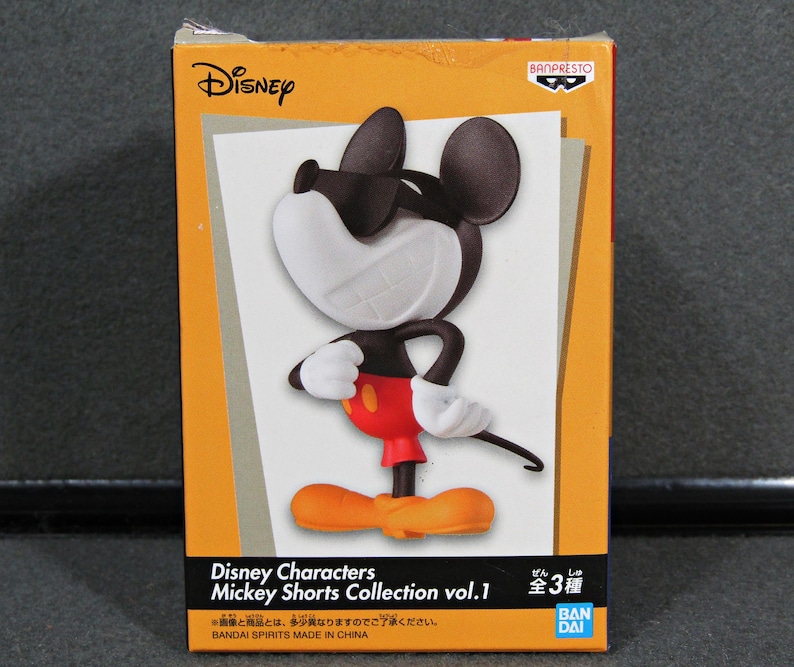 May include: A boxed Disney Mickey Mouse figurine from the Mickey Shorts Collection vol. 1. The figure is black, white, red, and orange, with Mickey in a confident pose. The box is orange with the Disney and Banpresto logos.