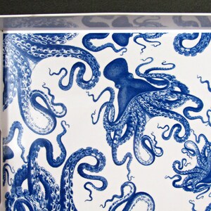 May include: A white serving tray with a repeating pattern of blue octopuses. The octopuses are depicted in a detailed, vintage style, with their tentacles curling across the tray's surface. The tray has a white border and cut-out handles.