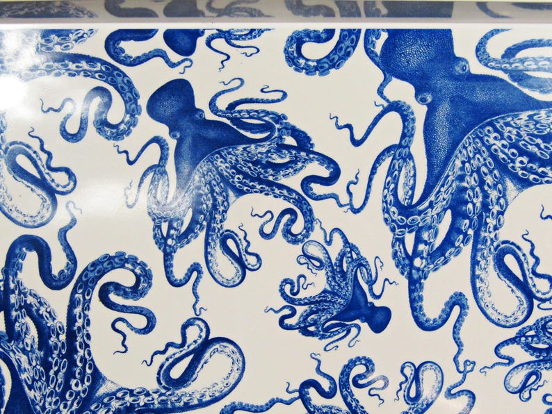 May include: White surface with a repeating pattern of blue octopuses. The octopuses are detailed with tentacles and suction cups, creating a nautical or marine theme. The design is reminiscent of a vintage illustration.