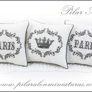 May include: Three white decorative pillows with black embroidery. The pillows feature a crown design and the word "PARIS" in a decorative font.