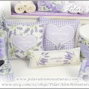 May include: A set of lavender-themed miniature pillows and a mug. The pillows are decorated with lavender flowers and the words "Lavender Love". The mug is white with a lavender floral pattern and the words "Lavender Love".