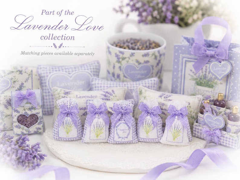 May include: A collection of lavender-themed items including small fabric sachets with purple bows, heart-shaped tags, a patterned mug, and a gift bag. The items feature lavender sprig illustrations and the text Part of the Lavender Love collection.