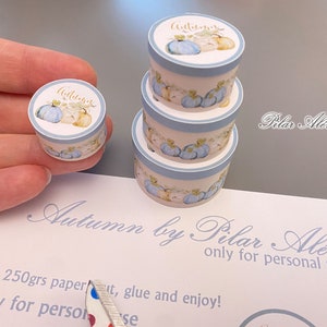 May include: A set of three blue and white paper boxes with a watercolor design of pumpkins and the word "Autumn" in gold lettering. The boxes are stacked on top of each other and are being held in a hand. The boxes are for personal use only.