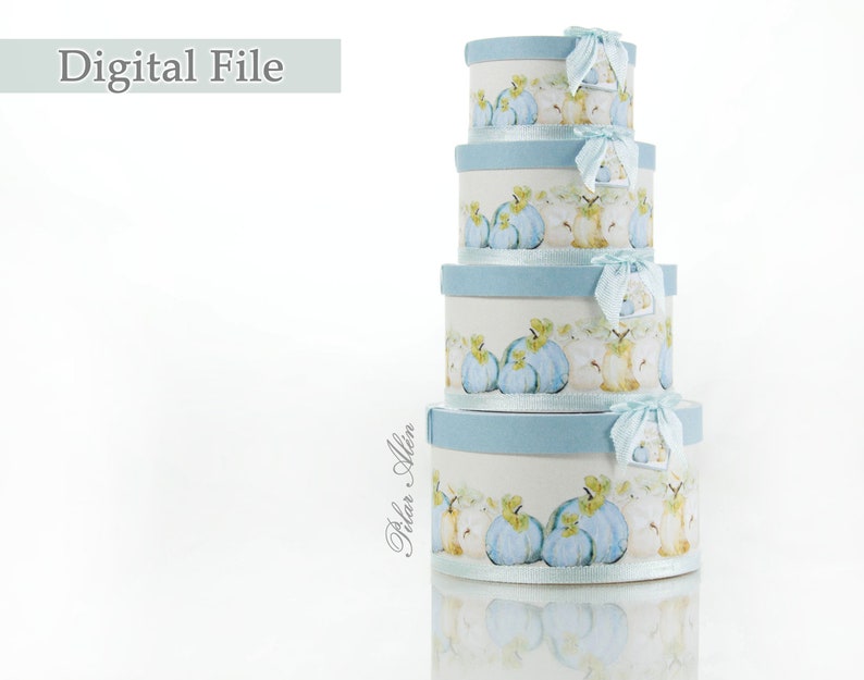 May include: Set of four round nesting boxes with a blue and white design featuring a watercolor illustration of pumpkins and apples. The boxes are stacked on top of each other.