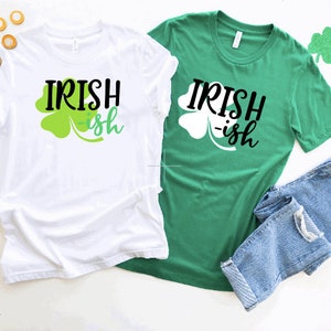 Könnte beinhalten: Zwei T-Shirts mit dem Text "Irish-ish" und einem Kleeblatt-Design. Ein Shirt ist weiß und das andere grün.