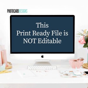 Puede incluir: Un monitor de computadora de escritorio que muestra el texto This Print Ready File is NOT Editable en fuente blanca sobre un fondo azul oscuro. El monitor se encuentra sobre un escritorio blanco con suministros, un cuenco rosa y flores.
