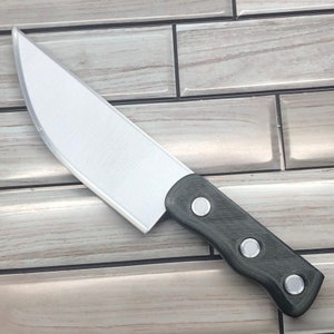 Puede incluir: Un cuchillo de cocina plateado con mango negro y tres remaches plateados. El mango tiene un agarre texturizado.