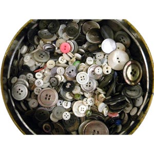 May include: A large collection of assorted sewing buttons in a round container. The buttons vary in size, shape, and color, including shades of white, gray, black, and brown, with a single bright pink button and a few small blue and green accents.