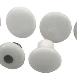 May include: A collection of white ceramic cabinet knobs in various shapes. The knobs include round, oval, and mushroom-shaped designs. Each knob has a glossy finish and a dark gray or black mounting screw.