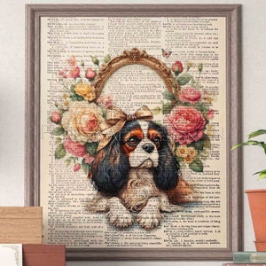 May include: A Cavalier King Charles Spaniel puppy with a pink bow sits in a vintage frame surrounded by colorful flowers. The background is a page from an antique dictionary with text about the word "low".