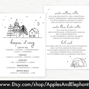 May include: Black and white illustration of a house and two trees with stars in the background. Text reads "keepin' it cozy" and lists different essential oil blends for "cup of tea", "fireside", "open air", "winter nap", and "winter walk".