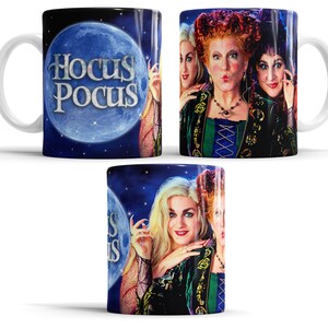 Op de afbeelding: Een witte keramische mok met drie heksen uit de film Hocus Pocus. De mok heeft een zwarte achtergrond met een blauwe maan en de woorden "Hocus Pocus" in wit.