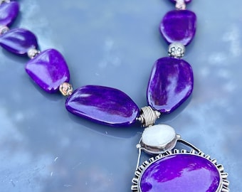 Collar de plata de ley con piedra sugilita púrpura pulida.