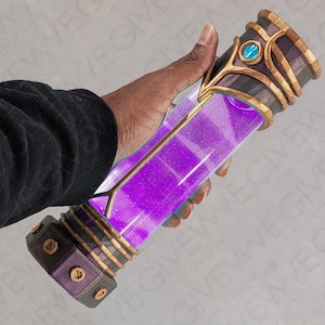 May include: A purple potion bottle with gold accents and a teal gem. The bottle is made of glass and has a wooden base.