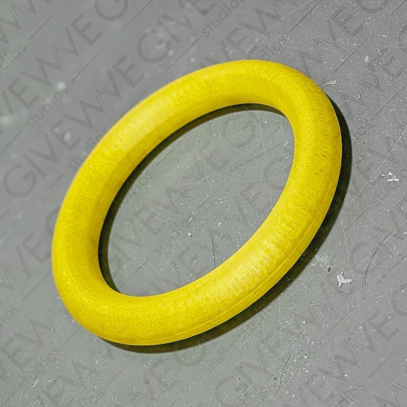 Puede incluir: Un anillo de madera amarillo, de aproximadamente 15 cm de di&aacute;metro, con una superficie lisa y ligeramente texturizada.